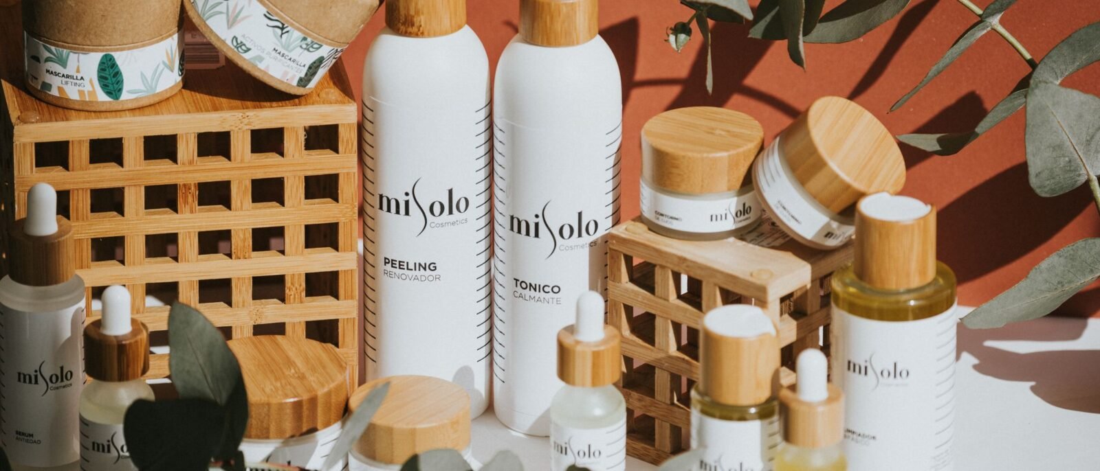 Flacon de sérum bio à pipette et pot de crème posés sur une planche de bois
